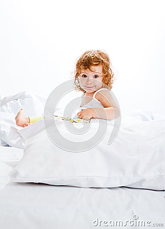 Curly toddler girl in bed Stock Photo