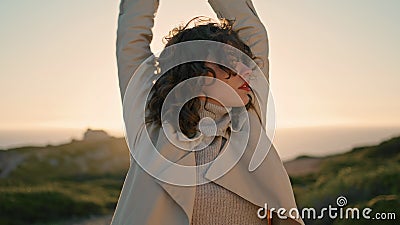 Curly woman evening sunlight stretching closeup. Thoughtful girl admire ocean Stock Photo