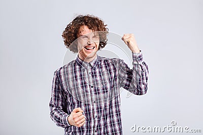 Curly young man surprised, joyful emotion on his face. Stock Photo