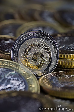 Currency of a Mexican peso between more coins Stock Photo