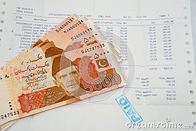 Currency notes in Pakistani Rupees with a paid invoice Stock Photo