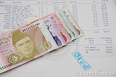 Currency notes in Pakistani Rupees with a paid invoice Stock Photo