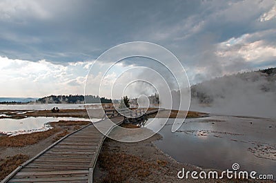 Curved Elevated wooden boardwalk going past Black Warrior Hot Springs and Tangled Creek into Hot Lake in Yellowstone National Park Stock Photo