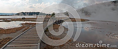 Curved Elevated wooden boardwalk going past Black Warrior Hot Springs and Tangled Creek into Hot Lake in Yellowstone National Park Stock Photo