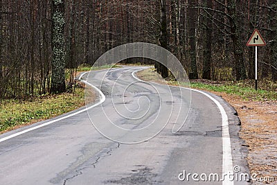 Curved empty road in woods in late autumn. Serene landscape Stock Photo