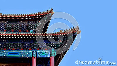 Curved roofs in traditional Chinese style with figures on the blue sky background. Stock Photo