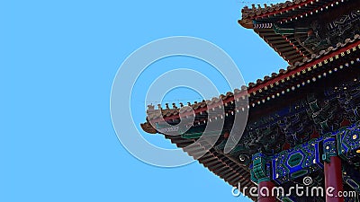 Curved roofs in traditional Chinese style with figures on the blue sky background. Stock Photo