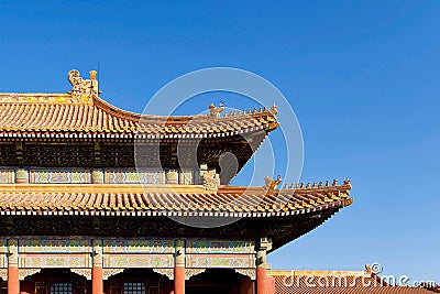 Curved roofs in traditional Chinese style with figures on the blue sky background. The Imperial Palace in Beijing Stock Photo