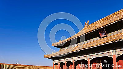 Curved roofs in traditional Chinese style with figures on the blue sky background. The Imperial Palace in Beijing Stock Photo