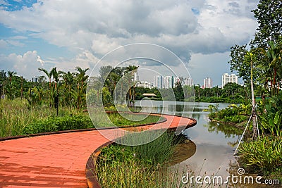 Curvy boardwalk beside the lake. Beautiful scenery with cloudy blue sky. Stock Photo