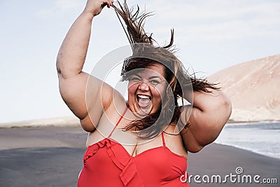 Curvy overweight woman smiling with beach on background - Focus on face Stock Photo