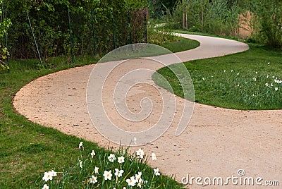 Curvy sandy path on the green grass Stock Photo