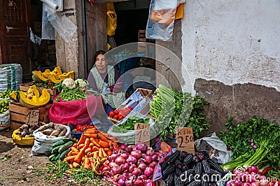 CUSCO, PERU - OCTOBER 8, 2016: Latin American woman sells fresh vegetables and fruits at the market Editorial Stock Photo