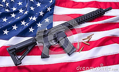 Custom built AR-15 carbine and bullets on American flag surface, background. Studio shot. Stock Photo