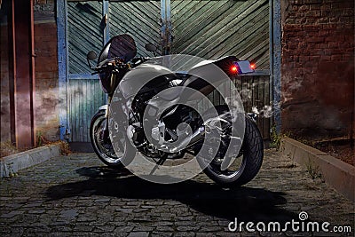 Custom caferacer motorbike on an old garage door background. Stock Photo