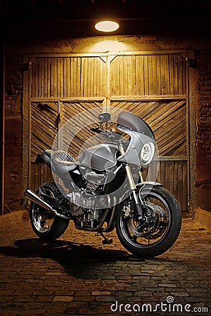 Custom caferacer motorbike on an old garage door background. Stock Photo