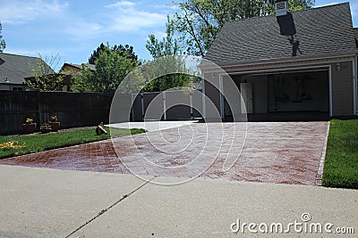 Beautiful stamped and colored concrete driveway glistening in the sun Stock Photo