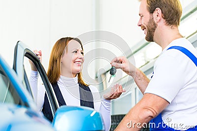 Customer and car mechanic in auto workshop Stock Photo