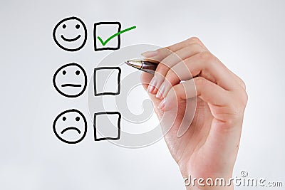 Customer Experience Concept, Hand with a pen with a checked box on Excellent Smiley Face Rating for a Satisfaction Survey Stock Photo