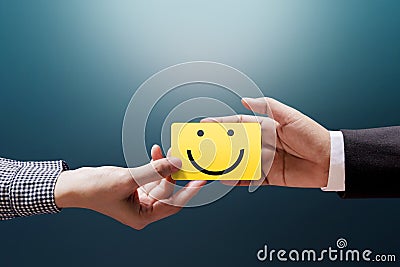 Customer Experience Concept, Happy Client Woman giving a Feedback with Happy Smiley Face Card into a Hand of Businessman Stock Photo