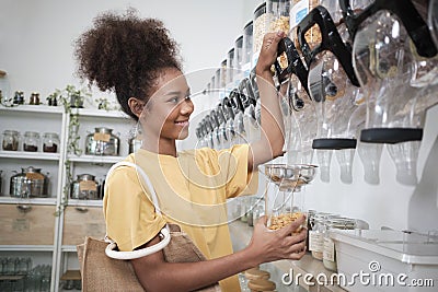 A customer fills cereal foods in a glass jar in a refill retail store Stock Photo