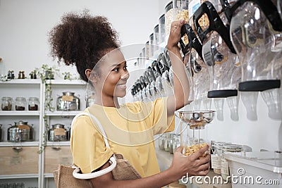 A customer fills cereal foods in a glass jar in a refill retail store Stock Photo