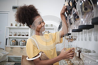 A customer fills cereal foods in a glass jar in a refill retail store Stock Photo