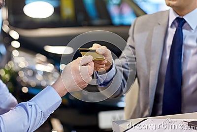 Customer giving credit card to car dealer in salon Stock Photo