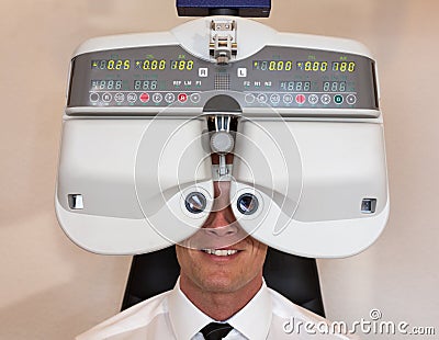 Customer of a optometrist or optician looking through phoropter Stock Photo