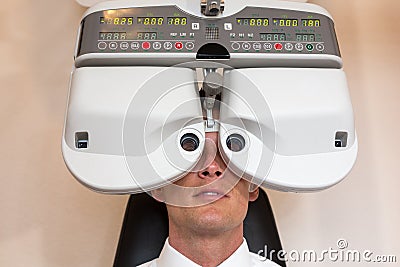 Customer of a optometrist or optician looking through phoropter Stock Photo