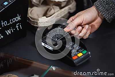 Customer is paying with contactless credit card in shop. Editorial Stock Photo