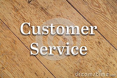 `Customer Service` white text on a wooden background. Stock Photo