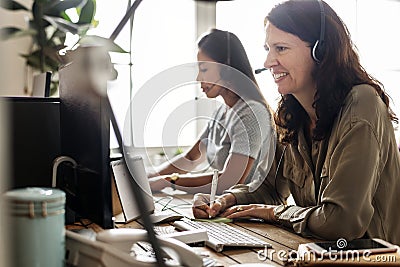 Customer service workers sitting in front of computers working Stock Photo