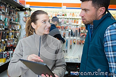 Customer showing digital tablet to vendor in hardware store Stock Photo