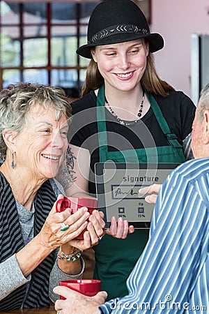 Customer Signs Tablet to Pay in Coffee House Stock Photo