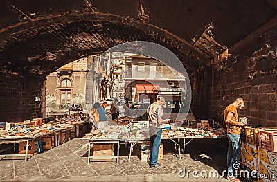 Customers of antique market reading old books under city bridge, the place for weekend flea market Editorial Stock Photo