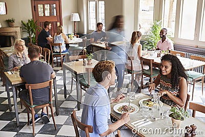 Customers Enjoying Meals In Busy Restaurant Stock Photo
