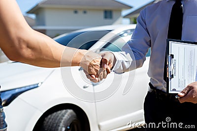 Customers shake hand with car insurance agents to enter into friendly terms and conditions Stock Photo