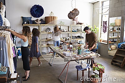 Customers and staff in a busy clothes shop Stock Photo