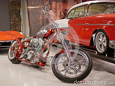 Customized motorcycle with v-twin cylinder motorcycle engine with chrome coating. Orange motorcycle frame with white flames. Editorial Stock Photo