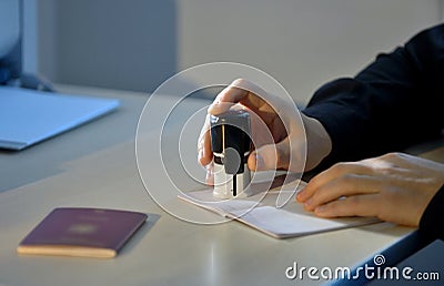 Customs Officer Stamping a Passport Stock Photo