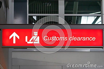 Customs sign in Airport and direction arrow, red and lighted. Stock Photo