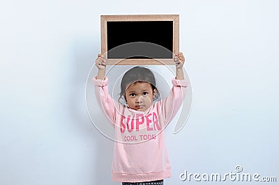 Cut asian girl holding blank chalkboard or blackboard. You can text it back to school Stock Photo