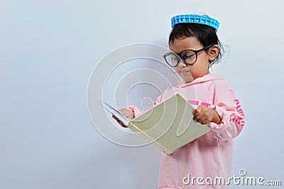 Cut asian girl wear glasses then open a book and read a book seriusly Stock Photo