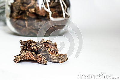 Cut dry root of Rhodiola rosea in a glass jar on natural white background Stock Photo