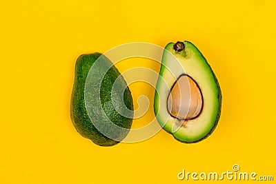 Cut fresh ripe avocado on yellow background Stock Photo