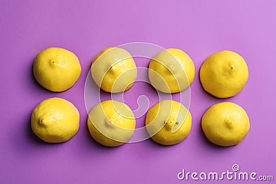 Cut lemons symbolizing women`s breasts and one with nipple piercing on purple background, flat lay Stock Photo