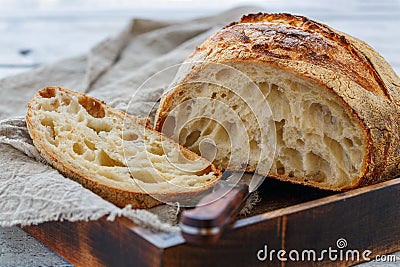 Cut loaf of artisanal wheat bread on sourdough. Stock Photo