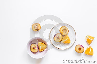 Cut peach and orange for exotic fruit on plates white background top view mockup Stock Photo