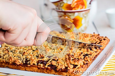 Cut sweet tart pastry with apple jam, hands Stock Photo